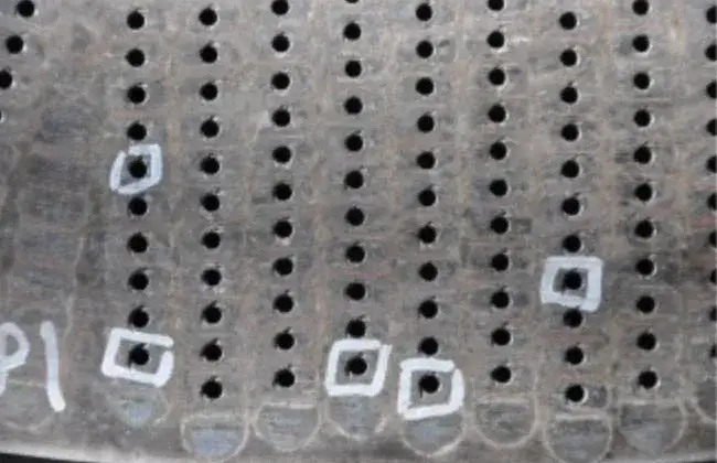 Die plate face with worn holes marked in white