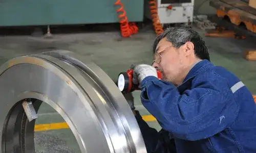 Technician inspecting a large circular metal component